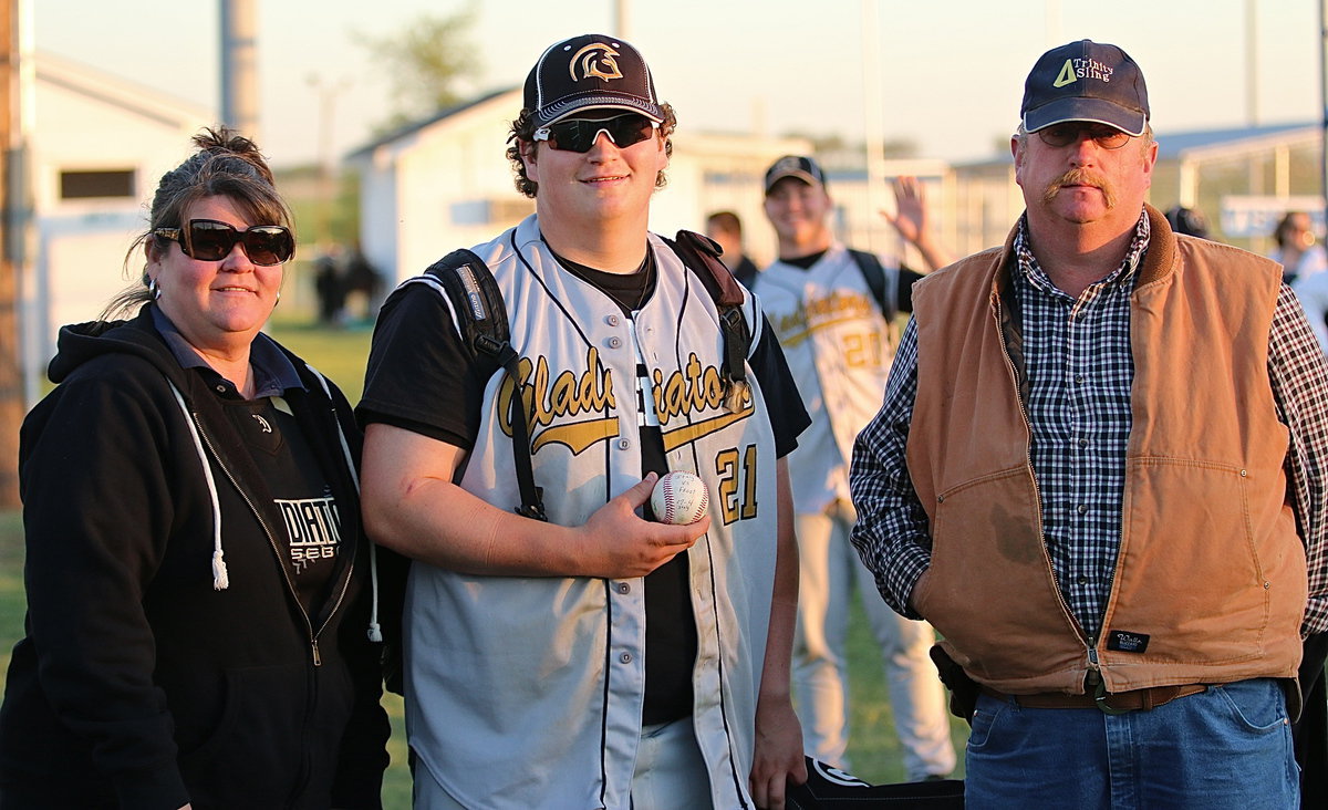 Image: Proud parents Nancy and Brent Byers with their son John Byers(21) as he displays his over-the-fence (and thru the uprights) homerun ball in Frost. Photo bomb by cousin and teammate Zain Byers(21) who didn’t hit one over.