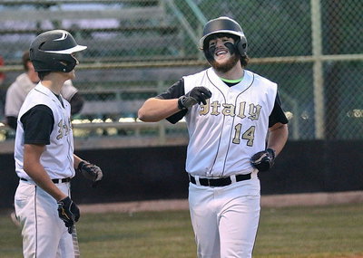 Image: Wounded, weary but happy, Kyle Fortenberry(14) makes it across home plate where he is congratulated by Levi McBride(1).
