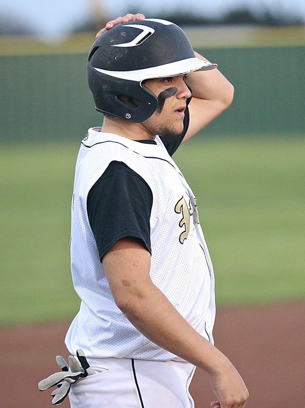 Image: Tyler Anderson(11) straightens his helmet in preparation for a play at the plate.