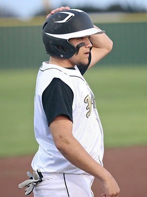 Image: Tyler Anderson(11) straightens his helmet in preparation for a play at the plate.