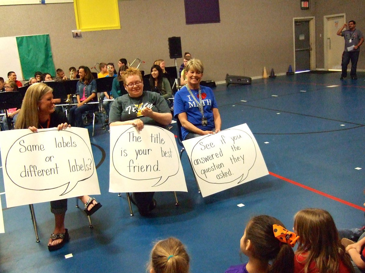 Image: Three more teachers having fun holding their questions.