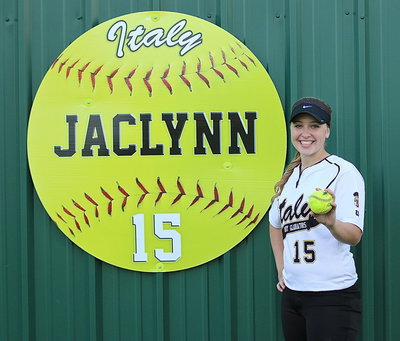 Image: Jaclynn Lewis(15) displays her home run ball that sailed over the green wall, just above her personalized softball sign.