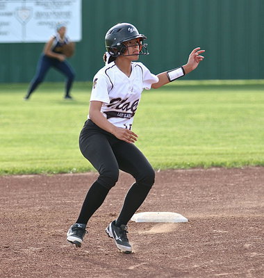 Image: April Lusk(18) rounds second-base but plays it safe before taking third.