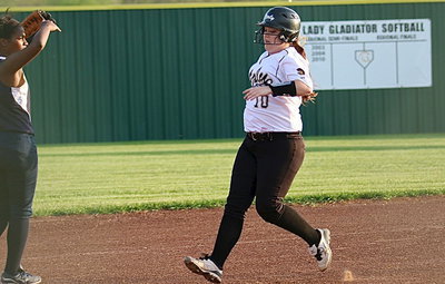Image: Senior hitter Paige Westbrook(10) pulls up at third after recording a triple.