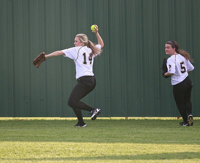 Image: Center fielder Kelsey Nelson(14) muscles a ball in from back near the wall as teammate Tara Wallis(5) backs her up.