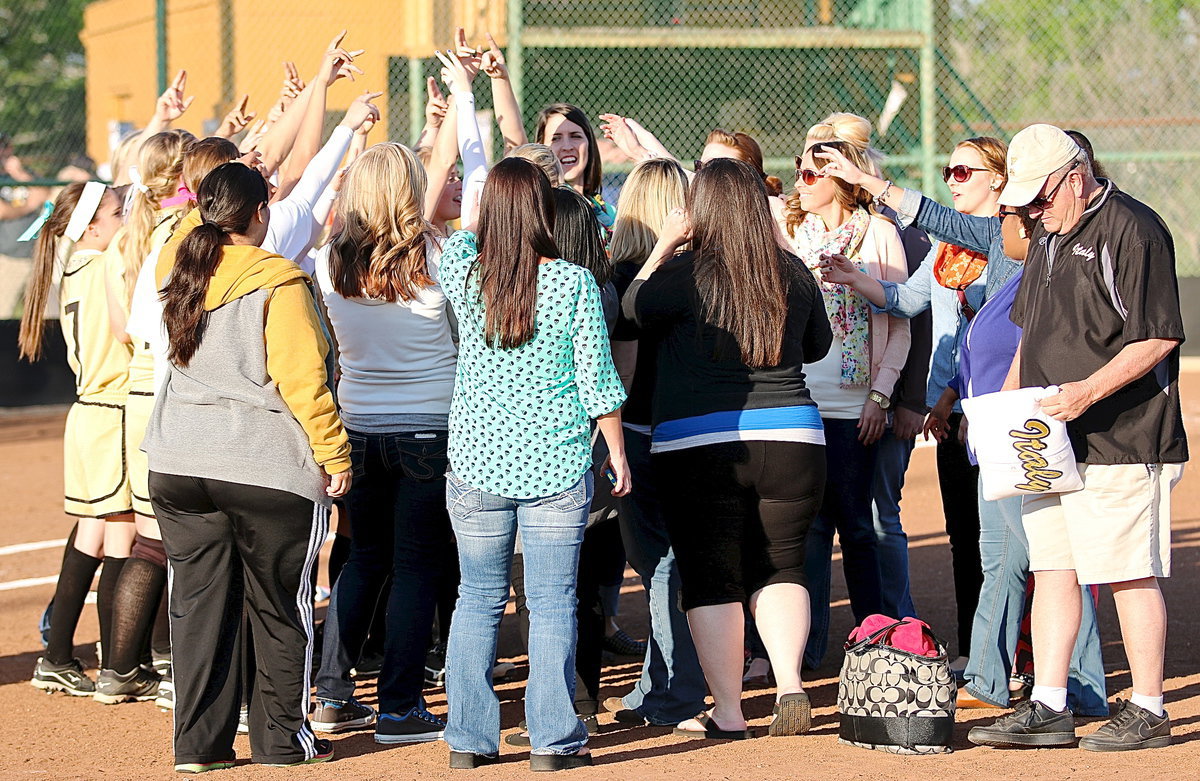 Image: Alumni and current Lady Gladiator softball players join together in the huddle in a display of team unity that stretches across generations.