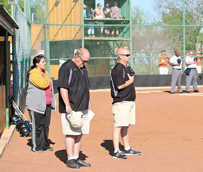 Image: Alumni Lady Gladiator softball player Tessa Tovar South, honors the flag, along with coaches Johnny Jones and Michael Chambers, before she handled the honor of throwing out the ceremonial first pitch.