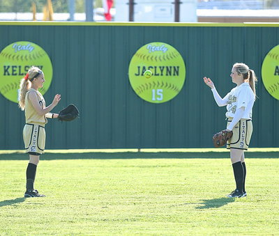 Image: Outfielder Britney Chambers(1) and Kelsey Nelson(14) play toss between innings.