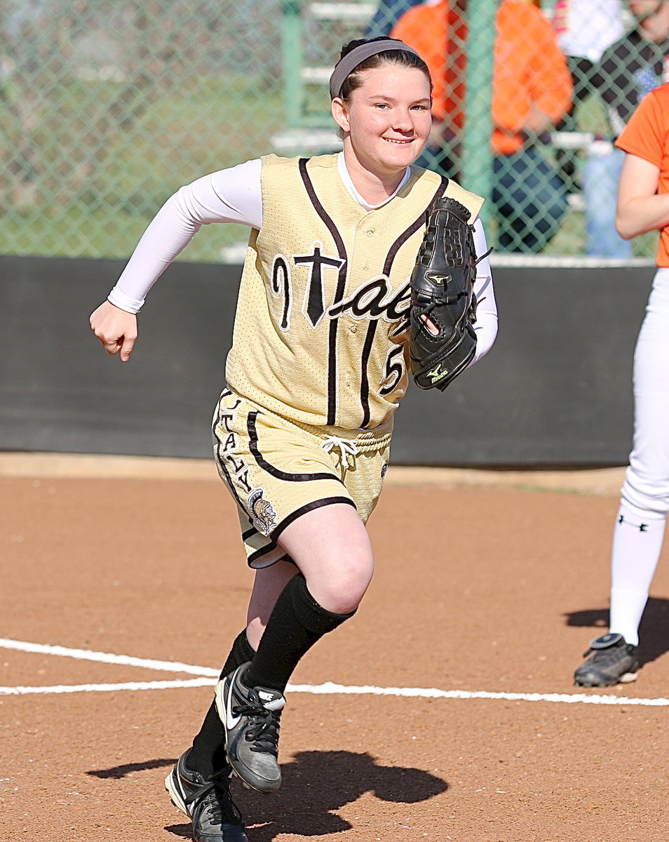 Image: Lady Gladiator Tara Wallis(5) hustles out to the diamond after being introduced before the start of the game.