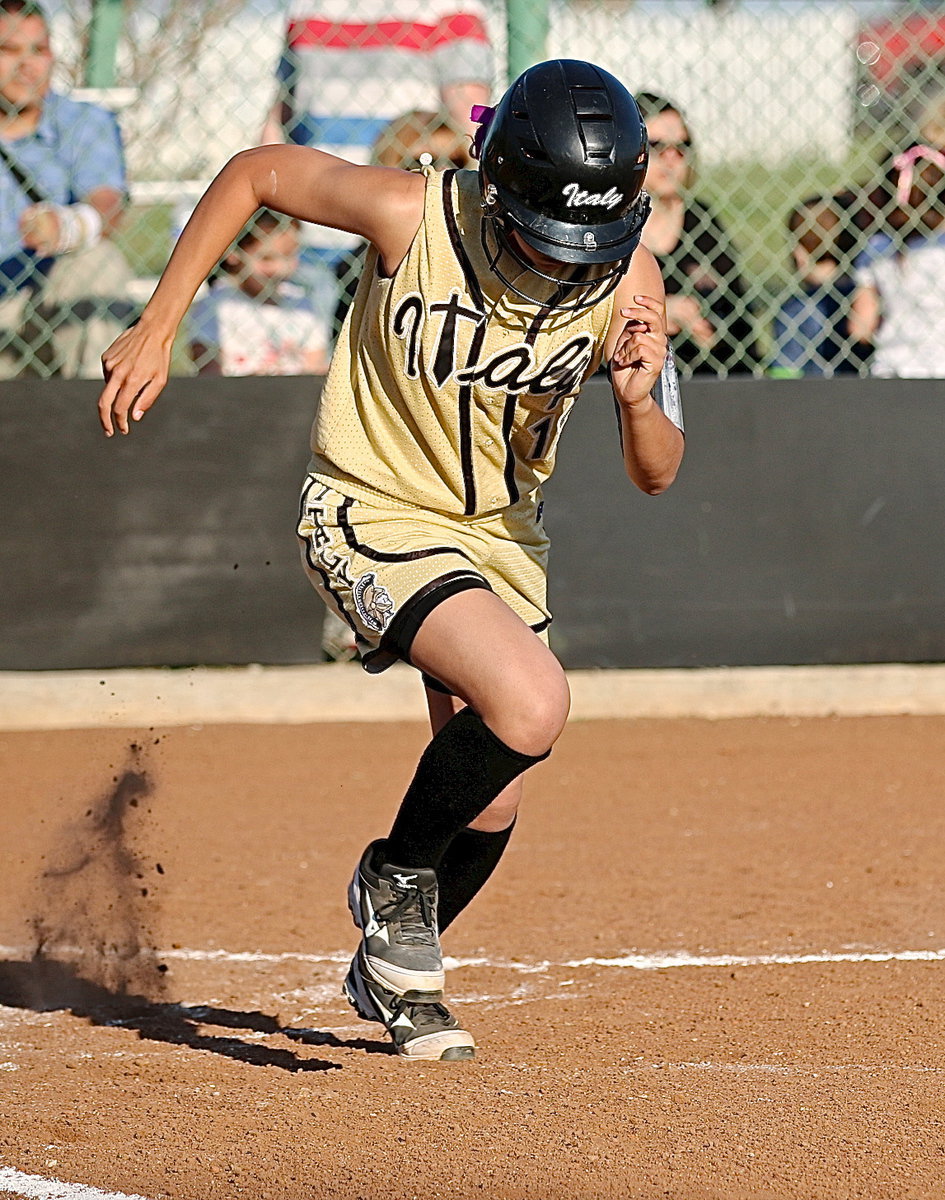 Image: April Lusk(12) hits and then runs to first-base.