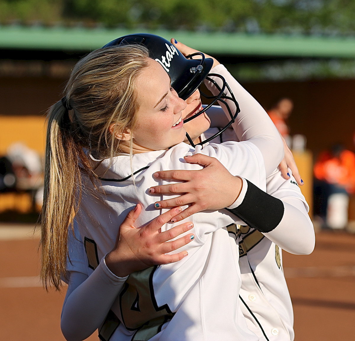 Image: Kelsey Nelson(14) congratulates an elated Amber Hooker(4) after Hooker scored the game ending run for the Lady Gladiators.