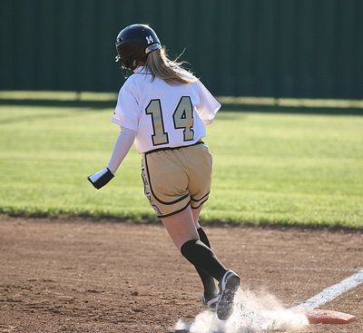 Image: Kelsey Nelson(14) stirs up the chalk as she turns for second-base with a double.