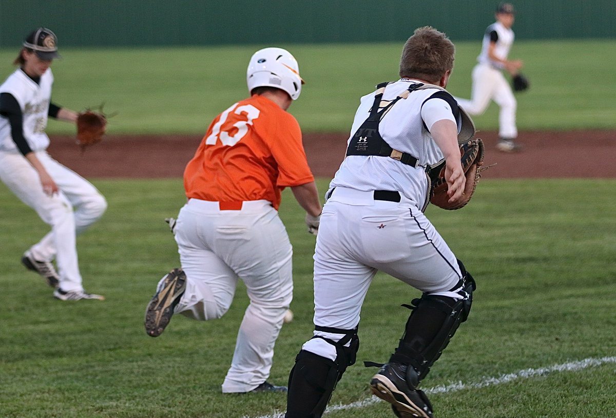 Image: Catcher John Escamilla(7), pitcher Ty Windham(12) and their fellow infielders converge on the ball to get the out at first-base.