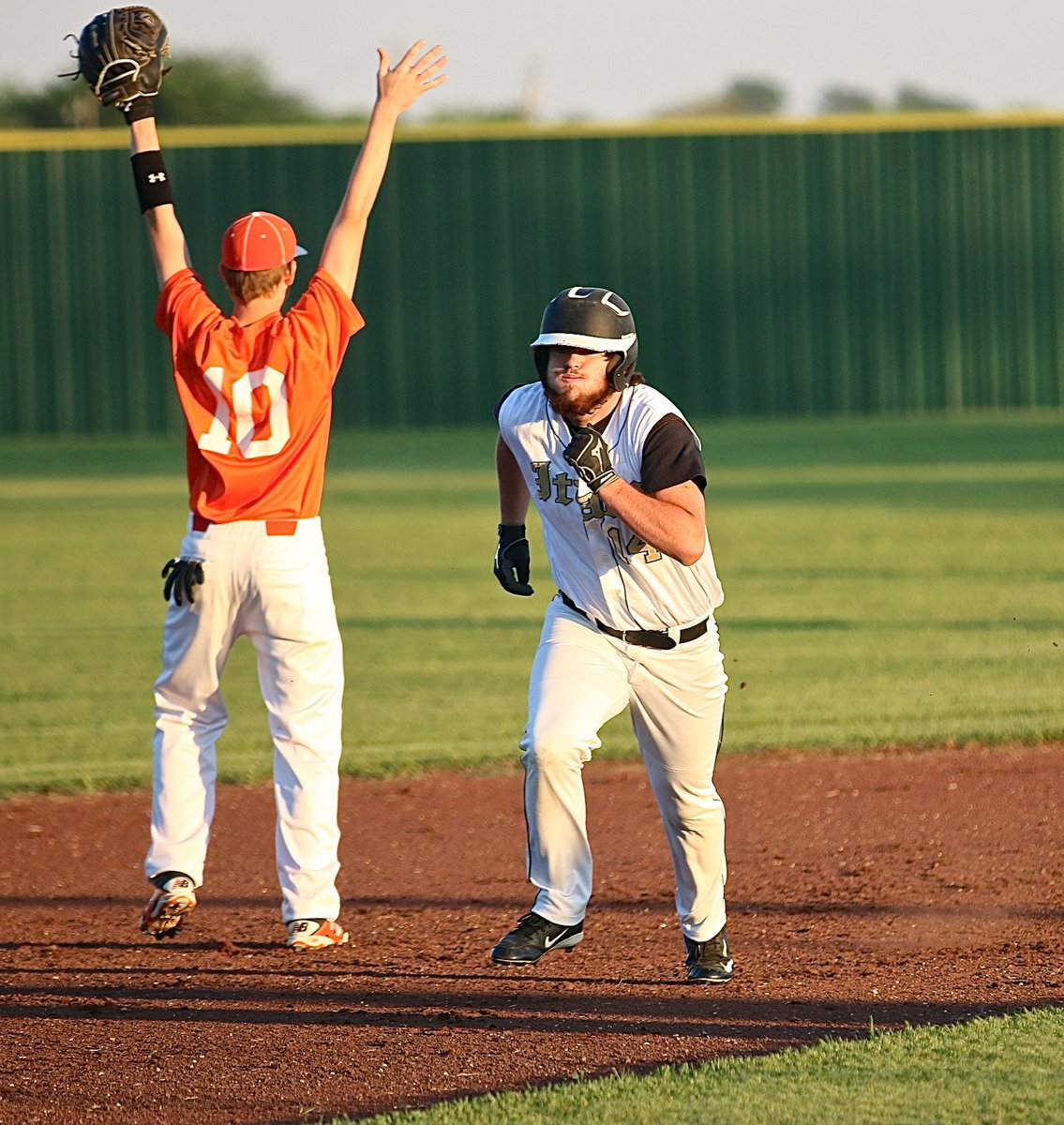 Image: Junior Kyle Fortenberry(14) huffs and puffs his way to third-base for the Gladiators.