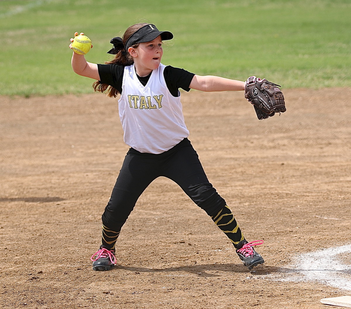 Image: Kinley Cate covers a grounder and then throws to teammate Paige Butler waiting at first-base for the out.