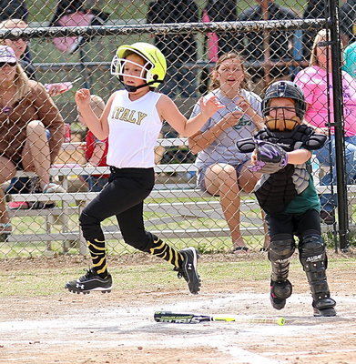 Image: Ella Hudson avoids the tag at the plate to score a run.