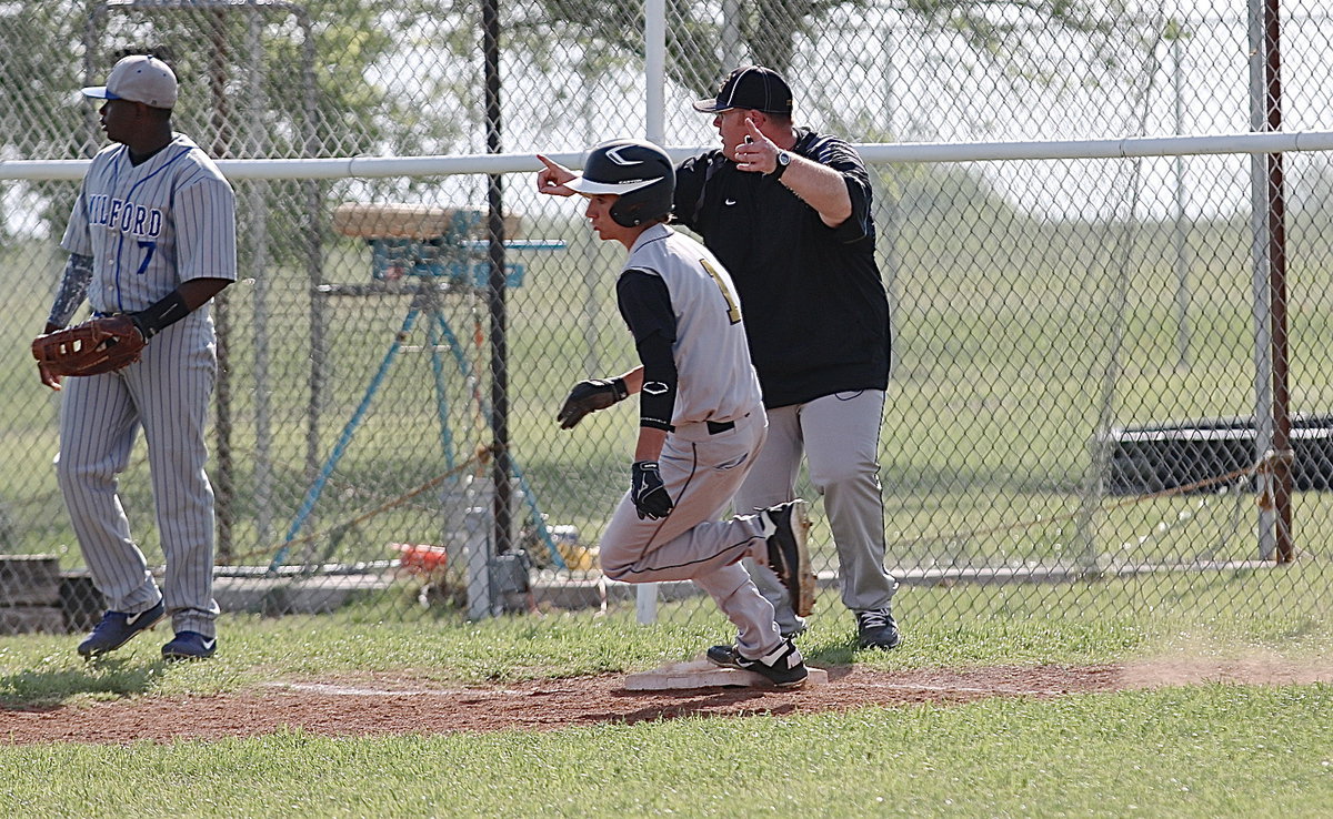 Image: Italy’s Levi McBride(1), a sophomore, leads off the district showdown against Milford with a triple into right field as assistant coach Brandon Gansky gives McBride the go sign!