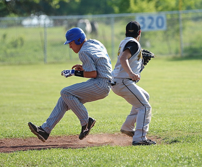 Image: MIlford’s Eric Evans(3) slips past a tag attempt from Italy’s shortstop, Tyler Anderson(9).