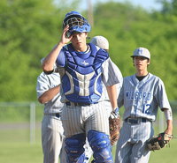 Image: Milford Bulldog catcher Bryan Fedrick exits a meeting at the mound and then returns to home plate with Frederick and his teammates hoping to grind out a win against Italy.