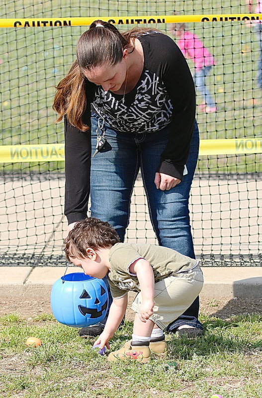 Image: Stephanie Latimer helps out one of her little ones in the toddler section of the Mayor’s Annual Easter Egg Hunt.