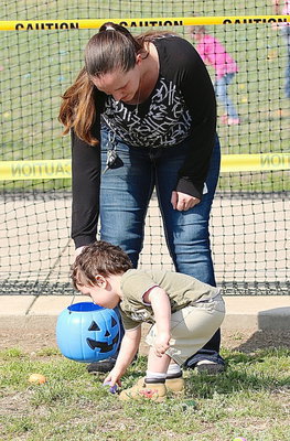 Image: Stephanie Latimer helps out one of her little ones in the toddler section of the Mayor’s Annual Easter Egg Hunt.