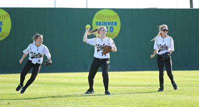 Image: Lady Gladiator center fielder Kelsey Neslon(14) hurries a ball back into the infield with fellow outfielders Tara Wallis(5) and Britney Chambers(4) backing her up.