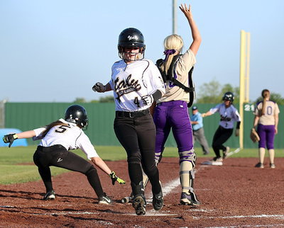 Image: Tara Wallis(5) gets the bat out of the way as fellow base runners Britney Chambers(4) and Bailey Eubank(1) hurry into score.