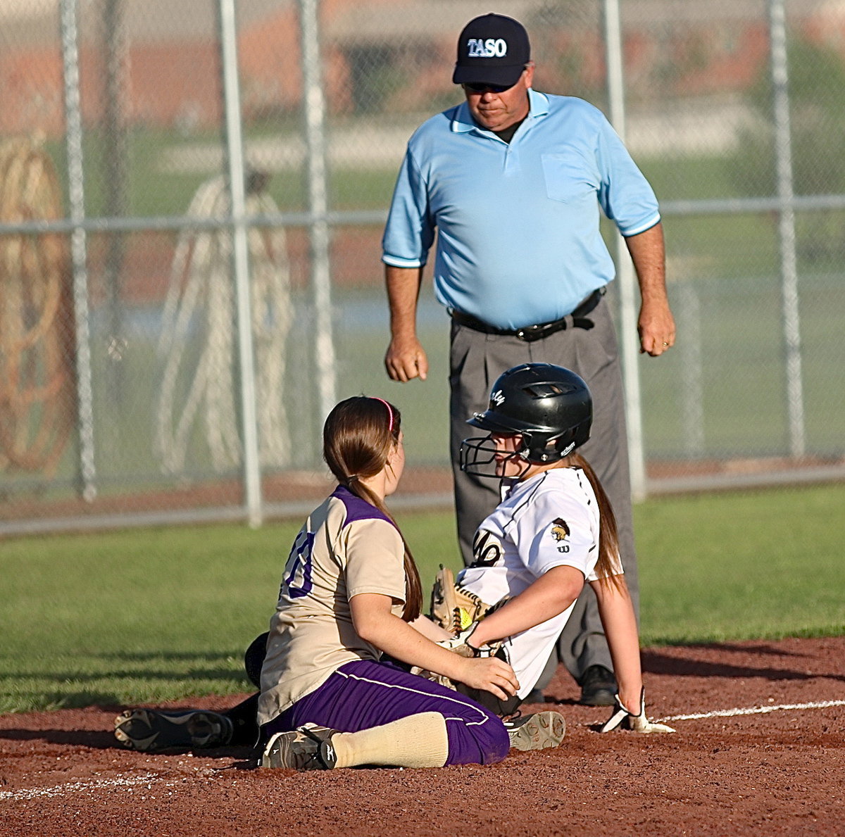 Image: Lady Gladiator Lillie Perry(9) slides into third-base and draws a safe sign from the ump after he takes a closer look.