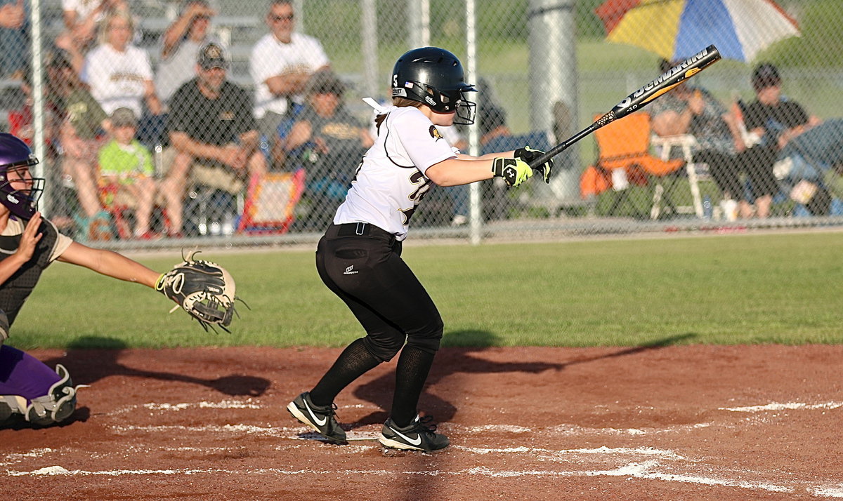 Image: Italy’s Tara Wallis(5) slap hits her way onto the base.