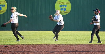 Image: Center fielder Kelsey Nelson(14) covers another ball hit into the outfield with Madison Washington(2) and Bailey Eubank(1) nearby if needed.