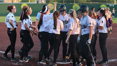 Image: Jaclynn Lewis(15) is congratulated by her teammates after Lewis’ home run put the Lady Gladiators in a position to rally back for the win.