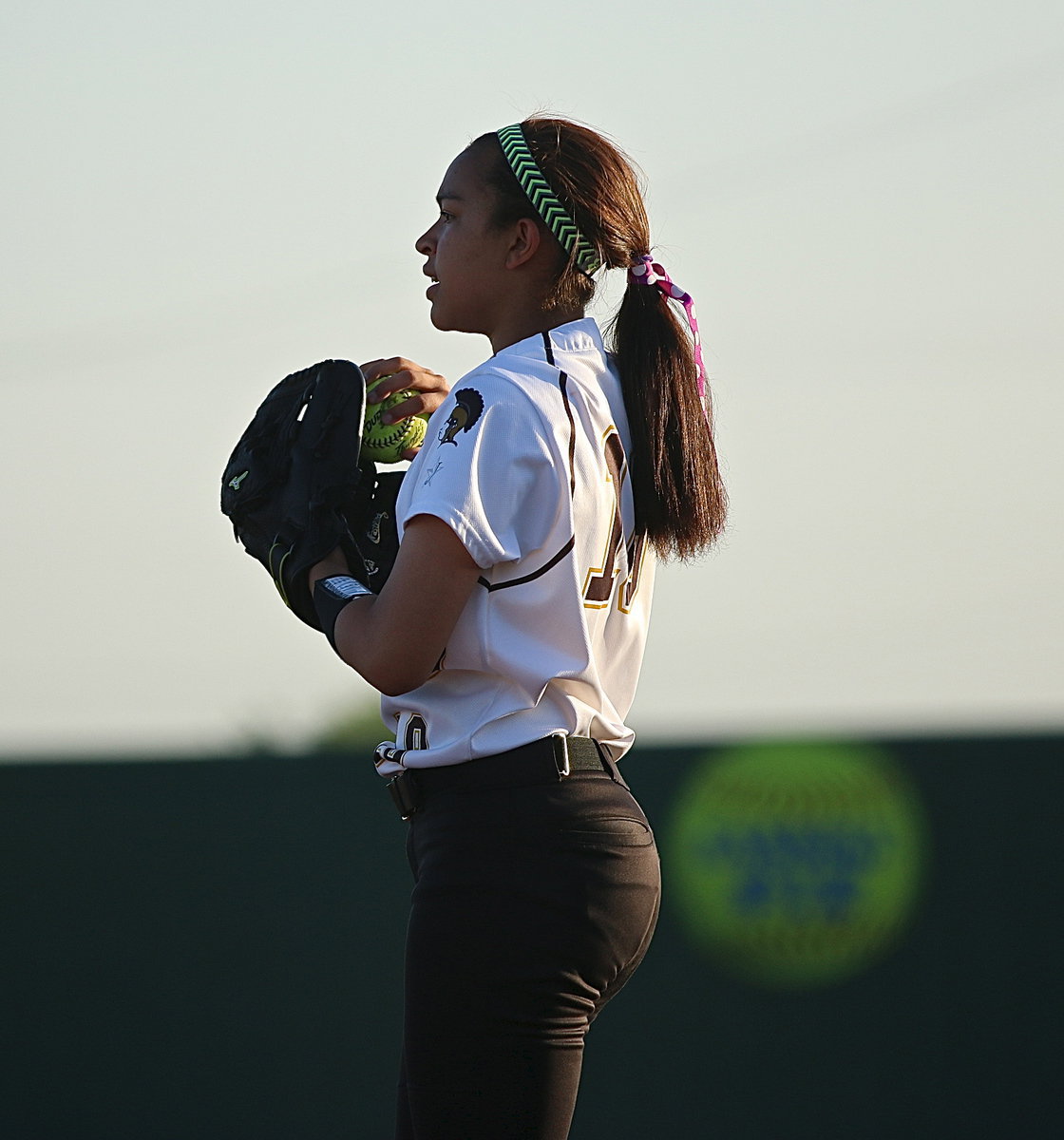 Image: April Lusk(18) warms up between innings.