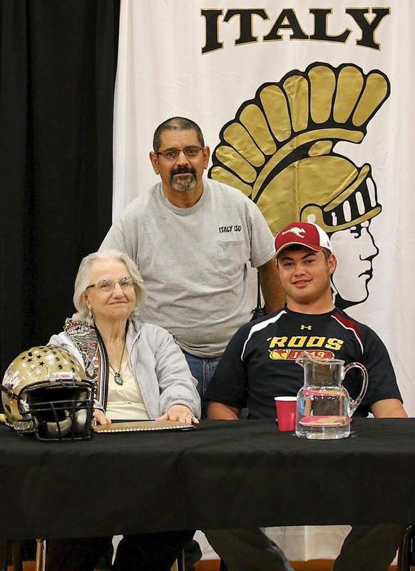 Image: Italy ISDs Joe Tovar congratulates Zain Byers on signing his commitment letter to join the ‘Roos with Zain saying "We’ve been thru a lot together, Joe." Also pictured is Zain’s proud grandmother, Ann Byers.