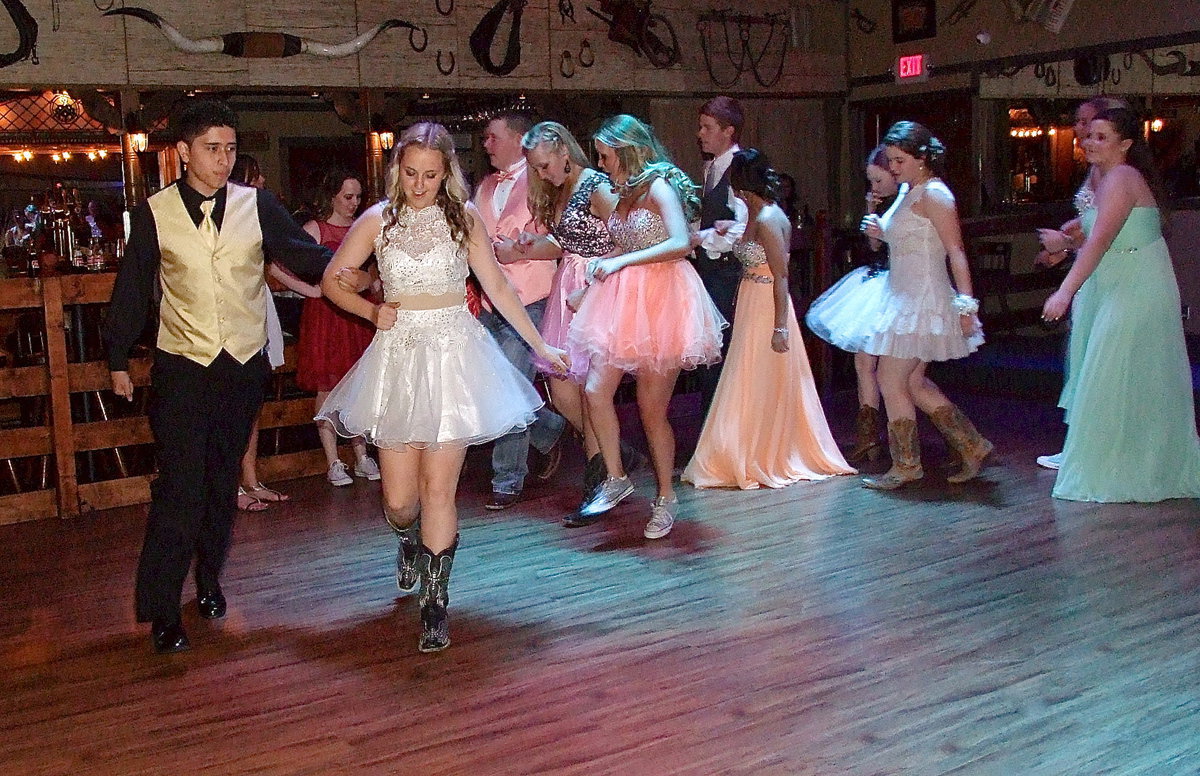 Image: Joseph Sage and Kelsey Nelson lead their fellow prom goers as they all dance in a circle to the Cotton-Eyed Joe. Italy’s prom was held inside E’s Southern Pass off Highway 45 in Ennis.