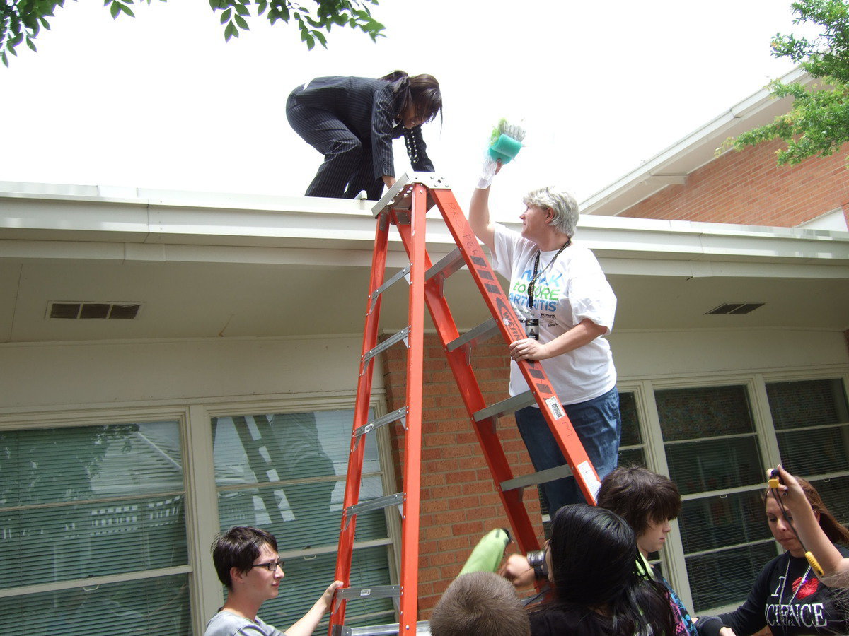 Image: Dee Dee Hamilton (school nurse) is handing up the eggs to Principal Thomas to drop them off the roof.