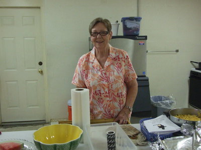 Image: Linda Goodman helps prepare the food for the luau.