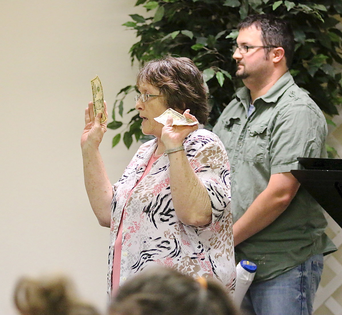 Image: Karen Mathiowetz offers $10 to Cody Medrano for being patient enough to be the last person in the food line. Karen explained, “Matthew 19:30 stated that whoever is first will be last and whoever is last will be first. She said that sometimes being first does not pay off but patience does.”