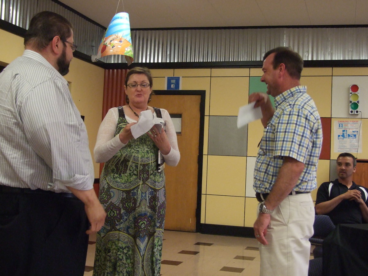 Image: Natasha Blackburn folds the nurse’s hat for Paul. Paul Cockerham has recently graduated from nursing school.