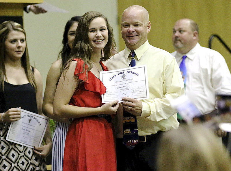Image: Amber Hooker is all smiles while accepting her sports participation certificate from Coach Michael Chambers.