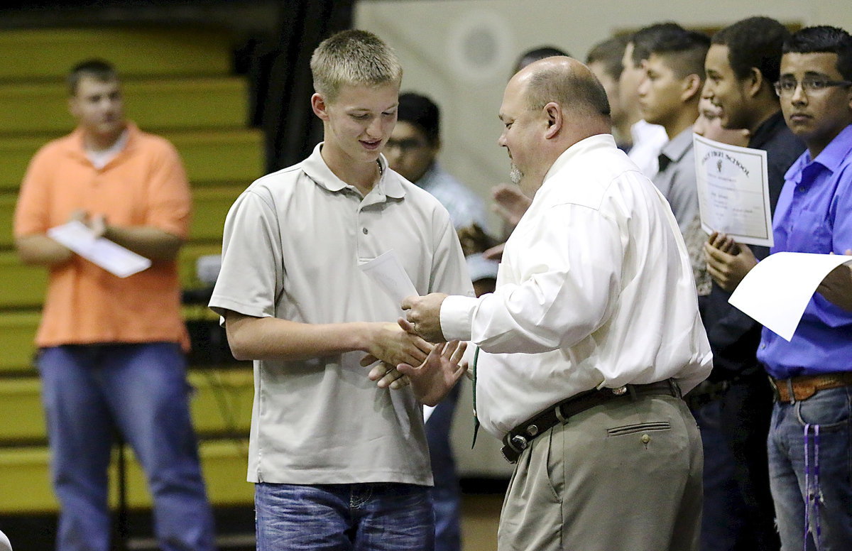 Image: Hunter Ballard accepts his sports participation certificate form Coach Wayne Rowe.