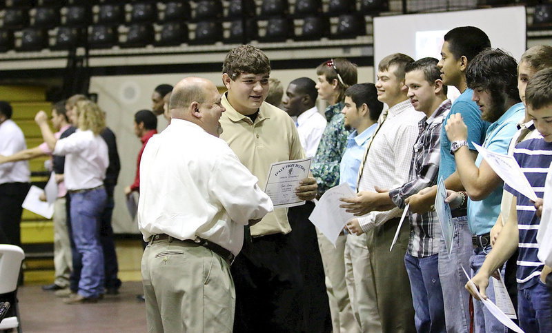 Image: Kevin Roldan accepts his sports participation certificate from Coach Wayne Rowe.