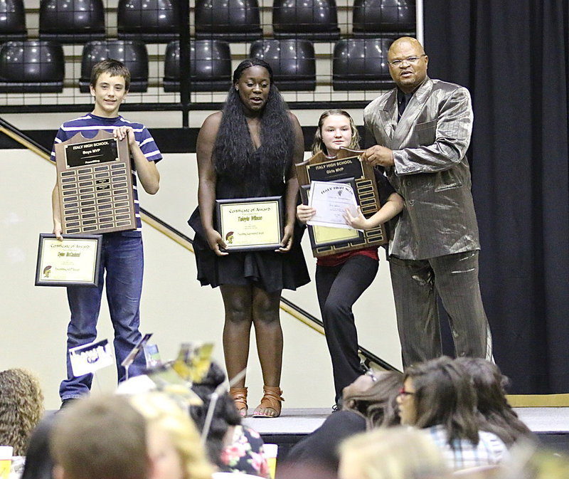 Image: Powerlifting Boys MVP Dyland McCasland, Taleyia Wilson and Girls MVP Tara Wallis, who, ironically, needed help lifting her trophy, pose with Coach Bobby Campbell.