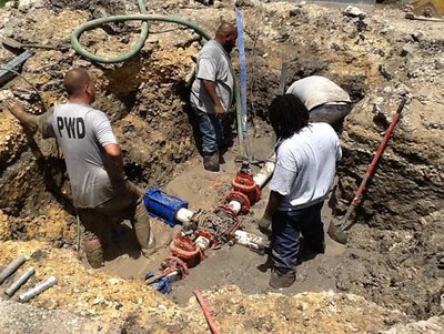 Image: The new valves and lines are in the ground and the Water crew is tightening and firming it in place.