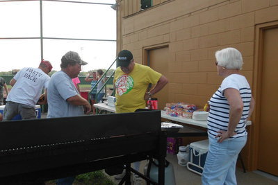 Image: Brian Mathiowetz grills hot dogs and visits with John Allen and Linda Erwin.
