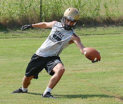 Image: Levi McBride shows his ability while reaching a pass low and behind him during a route running drill.