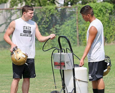 Image: Coby Jeffords takes care of his quarterback Joe Celis during a water break.