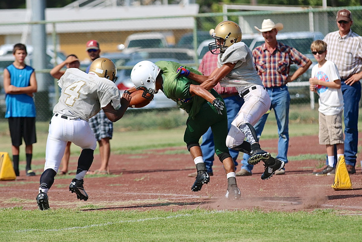 Image: JV Gladiators Kendrick Norwood(4) and Tylan Wallace(9) bring down an Eagle receiver the hard way.