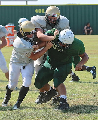 Image: Gladiator offensive linemen Aaron Pittman(64) and Kyle Fortenberry(50) team up to push back an Eagle defender.