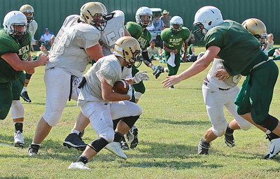 Image: Hunter Merimon(1) turns up behind teammates Austin Pittmon(58), Kyle Fortenberry(50) and Coby Jeffords(40) for extra yards.