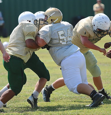 Image: JV Gladiator Sam Corley(54) fights off a double-team from his defensive tackle position.